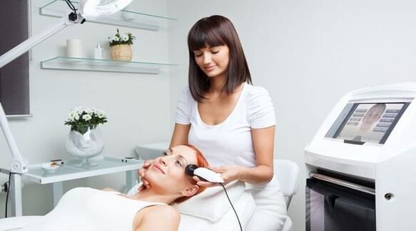 specialist conducts a session for skin rejuvenation with a device